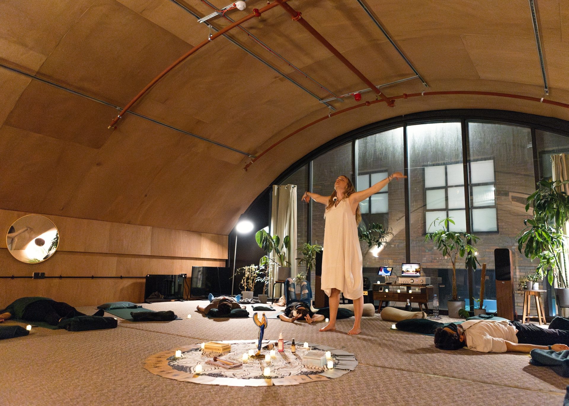 Maia holding a Kundalini Life Force ceremony at Self-Retreat Studio, participants lying around a candlelit altar