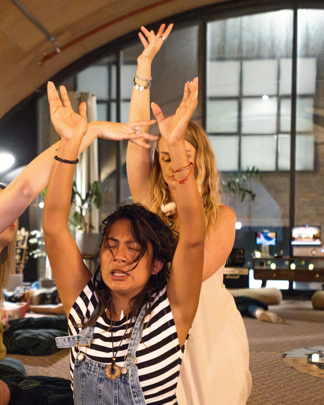 Both facilitators with arms raised over a participant