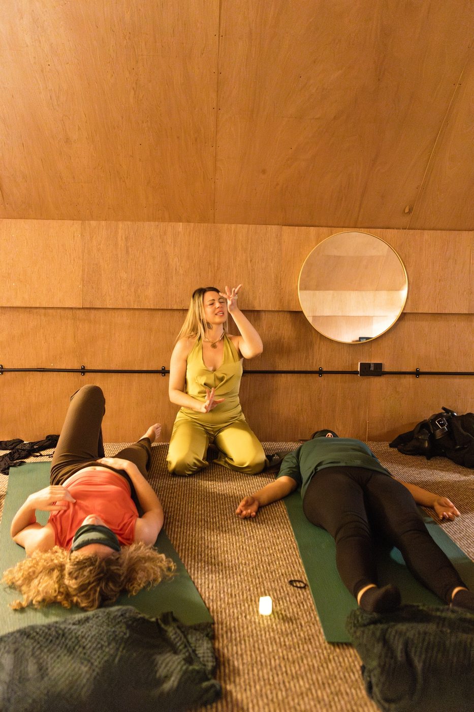 Participants resting on their backs as a facilitator sits nearby